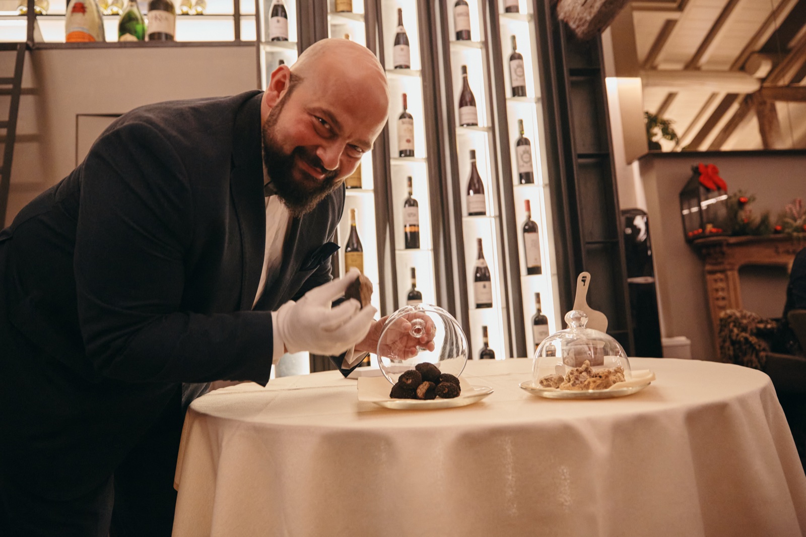 Daniele Violoni affetta il Tartufo al tavolo, accanto alle campane di vetro con i Tartufi
